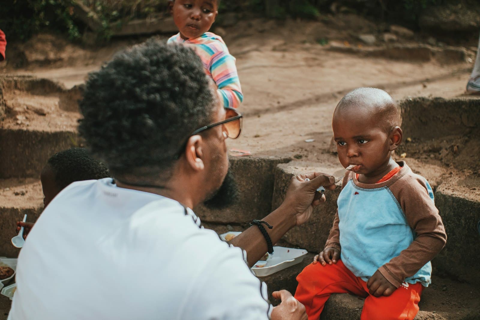 A volunteer sharing a meal with children
